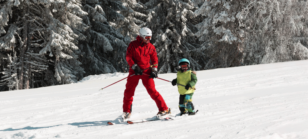 Moniteur de ski sur une piste avec un enfant