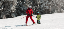 Ski instructor on ski run with a child