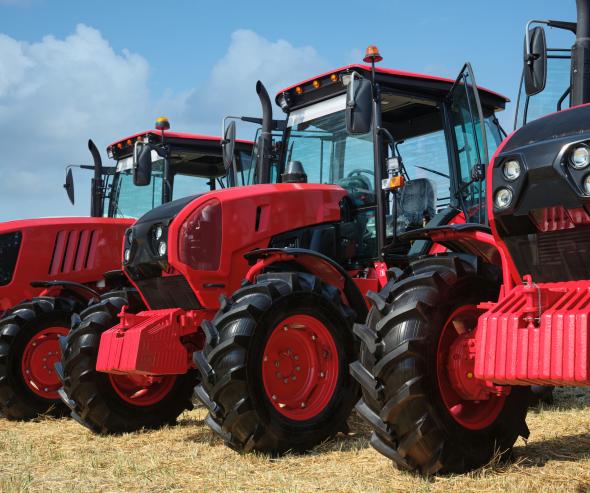 Plusieurs grands tracteurs rouges modernes dans un champ