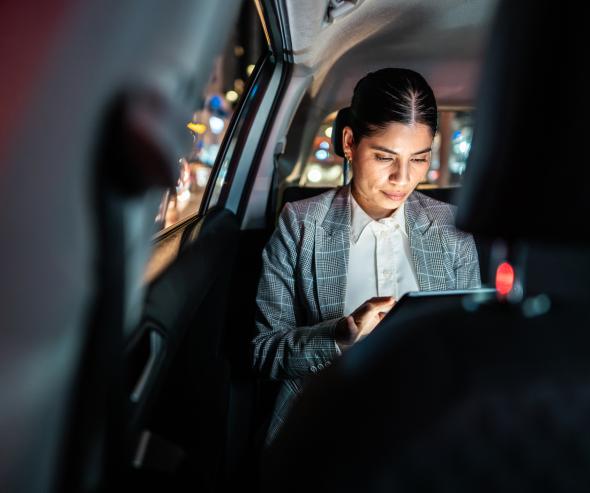 Femme d’affaires adulte moyenne utilisant une tablette numérique à l’intérieur d’un taxi - Photos